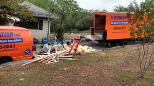 Water Damage Restoration Van And Truck With Debris Outside